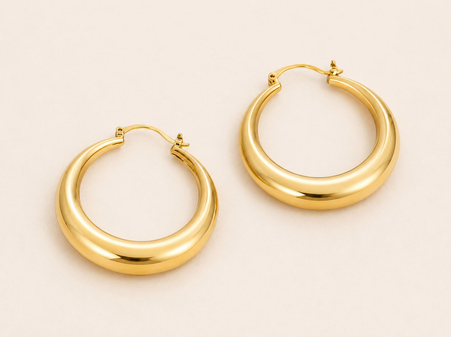 Classic bold stretched oval hoop earrings with mirror-polished seamless surface and latch closure